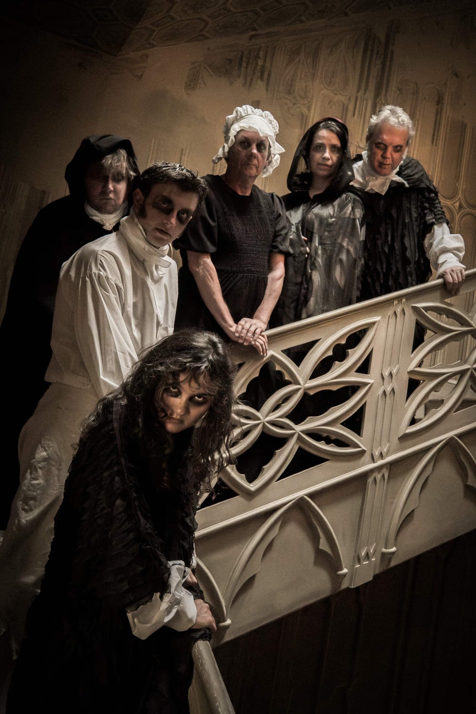 all actors in gothic clothes on a staircase
